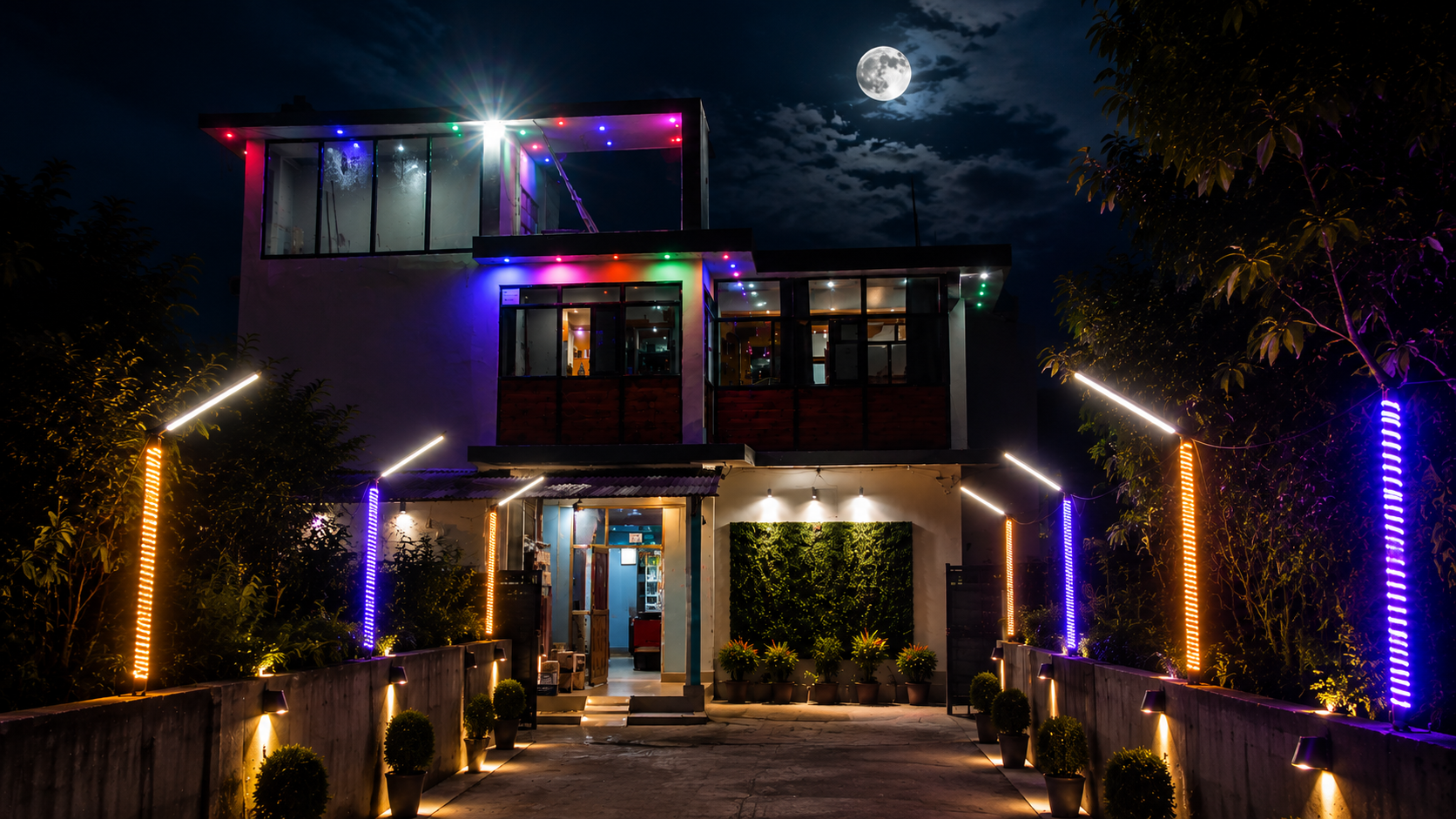 Jannat Restaurant & Lodge lit up at night with neon-lined entrance path