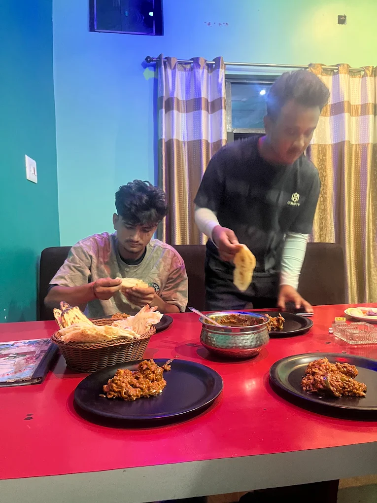 Guests sharing naan and curry at Jannat Restaurant